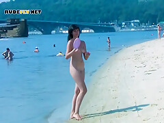 An Adorable Nudist Girls Strolls Around On The Beach And Lies Down