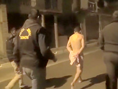 Cops walk a nearly naked criminal down the street