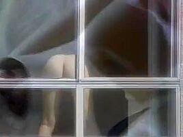 Horny Cunt Undresses In Front Of The Window And Fingers Her Pussy